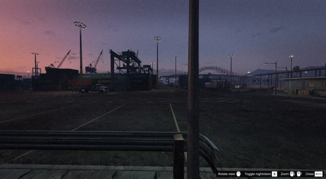 Night camera view of a container port with control hints for rotate view, toggle nightvision, zoom and close.