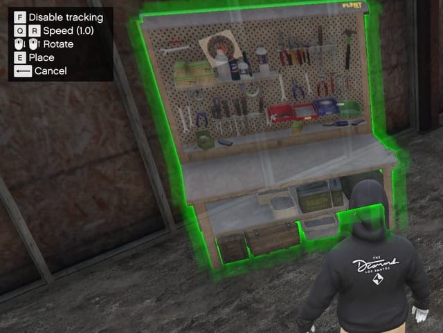 Green-outlined workbench with a pegboard of tools being placed in the world, with control hints for tracking, speed, rotate, place and cancel.