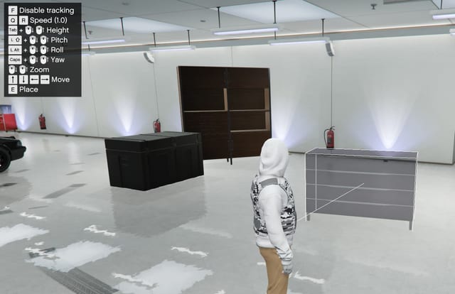 Furniture placement in a garage with a dresser outlined in white and control hints for tracking, speed, height, pitch, roll, yaw, zoom, move and place.
