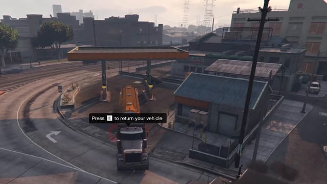 Truck with an orange tanker trailer stopped under a gas station canopy beside the shop, with the prompt "Press E to return your vehicle" above its cab.