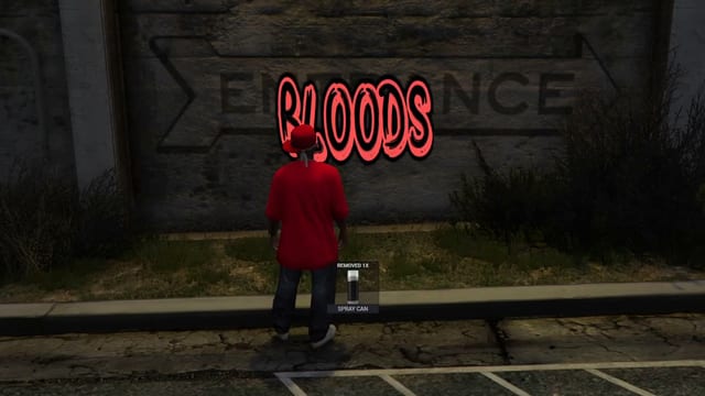 Player in a red shirt and cap standing at a concrete wall under a freshly sprayed red Bloods tag over the painted word Entrance, beside a Removed 1x Spray Can notice.