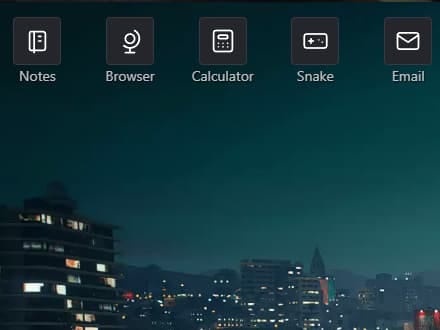Top-left corner of the laptop desktop over a city at night, with app icons for Notes, Browser, Calculator, Snake and Email.