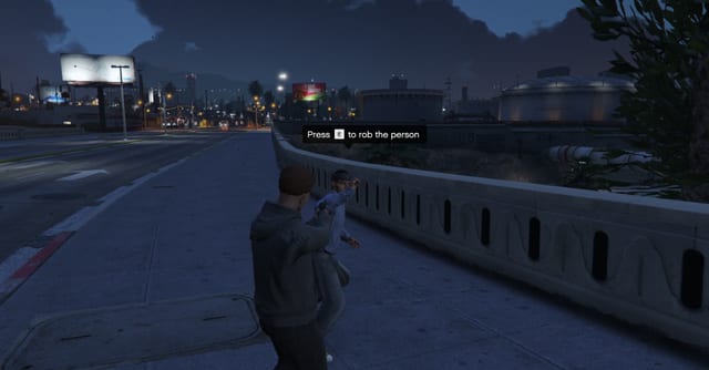 Player aiming at a passer-by on a road bridge at night with the prompt "Press E to rob the person".