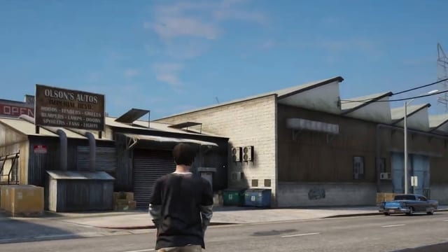 A player aims a zipline gun at a workshop roof across the street, a green pole appears beside him, and he rides the line up to the roof and then another line back down across the road.